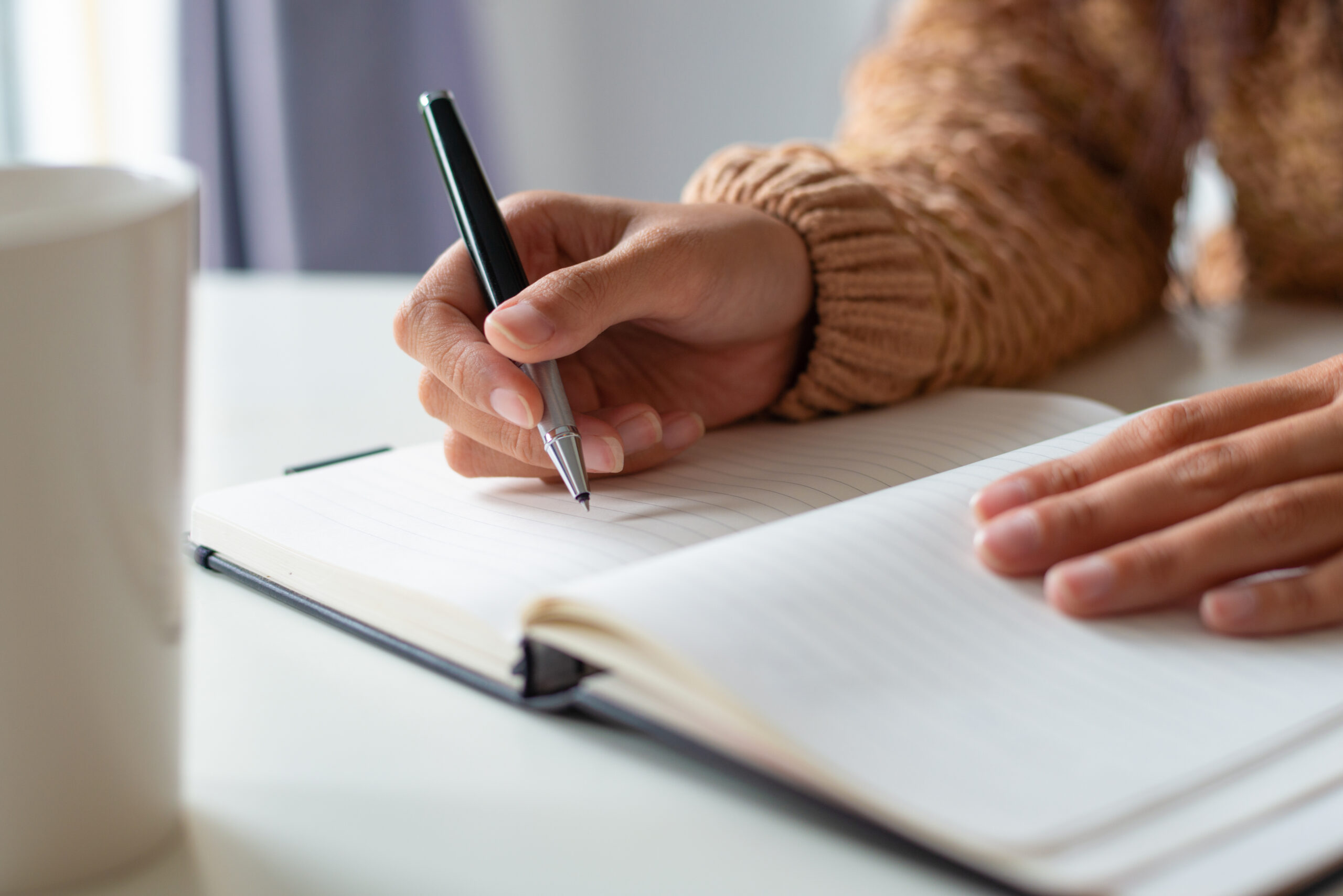 close up of woman sitting at table and planning schedule